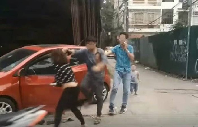 Hà Nội: Công an mời người chồng đánh vợ dã man trên phố lên làm việc - 1 Người dân đã quay clip chồng đánh đập vợ trên phố Trần Quốc Hoàn rồi đưa lên mạng xã hội (Ảnh cắt từ clip)
