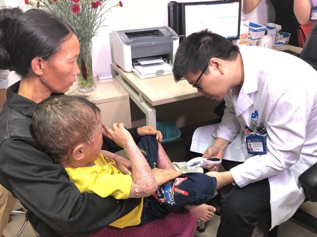 Cậu bé “người cóc” đau đớn vì sần sùi, bong vảy toàn thân - 2 PGS Lê Hữu Doanh khám cho bệnh nhi.