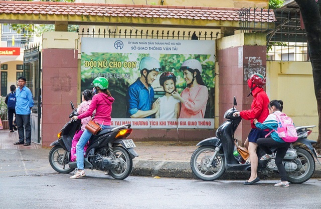 Hà Nội: Nhiều phụ huynh không đội mũ bảo hiểm cho con khi đưa trẻ tới trường - 1
Phóng viên Dân trí ghi nhận tại một số trường Tiểu học trên địa bàn Thủ đô Hà Nội, các phụ huynh khi đưa con đến trường đều đội mũ bảo hiểm nhưng lại không đội mũ bảo hiểm cho con.