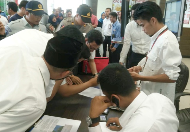 
Nhân viên của Lion Air kiểm tra danh sách hành khách trên chuyến bay JT610 gặp nạn. (Ảnh: Reuters)
