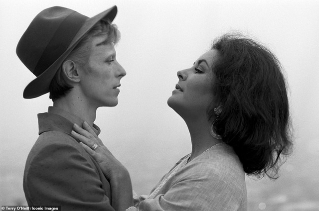 Khoảnh tự nhiên và “thần thái” của ngôi sao qua ống kính nhiếp ảnh - 3
Minh tinh Elizabeth Taylor gặp nam ca sĩ David Bowie trên phim trường “The Blue Bird” hồi năm 1975. Bowie đã đến phim trường thử vai muộn hai tiếng đồng hồ khiến nữ minh tinh rất giận. Bức ảnh này khiến Terry rất thích thú bởi David Bowie khi đó còn trẻ, có thể cảm thấy sự căng thẳng của Bowie khi diễn xuất thử bên Elizabeth.