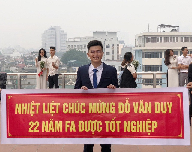 Nam sinh ĐH Luật được bạn bè mang băng rôn mừng “22 năm FA được tốt nghiệp” - 1 Văn Duy bên cạnh tấm băng rôn được các bạn làm tặng