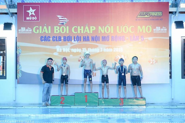 Lớp học của người thầy giáo đặc biệt: Trẻ dậy từ 4h40 để học bơi! - 2
Các học trò đội bơi mũ đỏ cùng người thầy của mình trong lễ nhận giải.