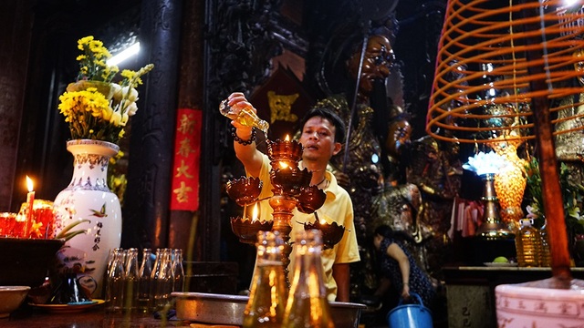 Du khách nước ngoài thích thú trước hình ảnh người dân đi chùa ngày rằm - 11 Phía bên trong Chánh điện bộ phận hỗ trợ Phật tử cũng liên tục dâng dầu giúp Phật tử