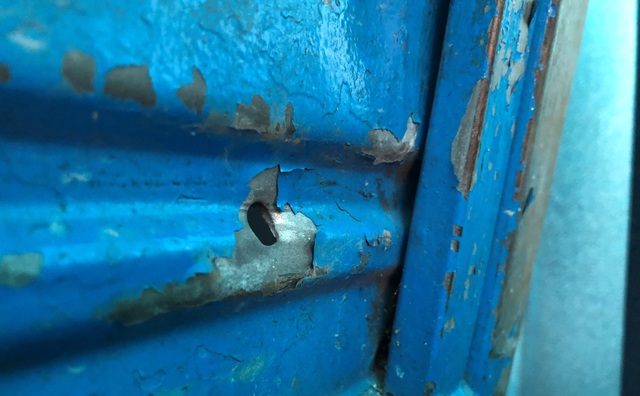 Khẩn trương điều tra vụ nổ nhiều phát súng, bắn người giữa khu dân cư - 4 Dấu vết viên đạn xuyên thủng chiếc xe bagác đậu trong sân nhà ông Châu.