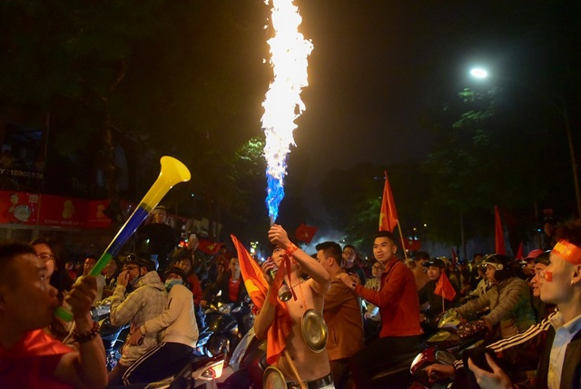 Hàng nghìn cổ động viên đổ về hồ Gươm ăn mừng chiến thắng trước Campuchia - 13 Một cổ động viên tạo lửa để ăn mừng chiến thắng.