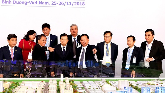 Sớm đưa Việt Nam vào nhóm các nước dẫn đầu ASEAN - 2 Phó Thủ tướng Trịnh Đình Dũng cùng các đại biểu tham quan mô hình thành phố mới Bình Dương.