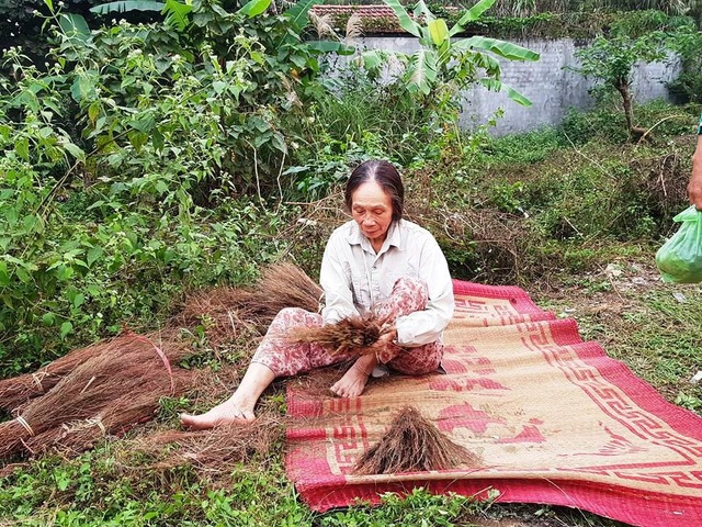 Ninh Bình: Người dân dựng lều, tập trung phản đối dự án xây đài hóa thân! - 5 Một người dân mang cả chổi ra ngồi bện bên đường để túc trực phản đối dự án.