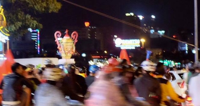 Người hâm mộ ào xuống đường trong mưa rét - 20
Người dân Đà Nẵng diễu trên phố với hình HLV Park Hang Seo và cup vàng