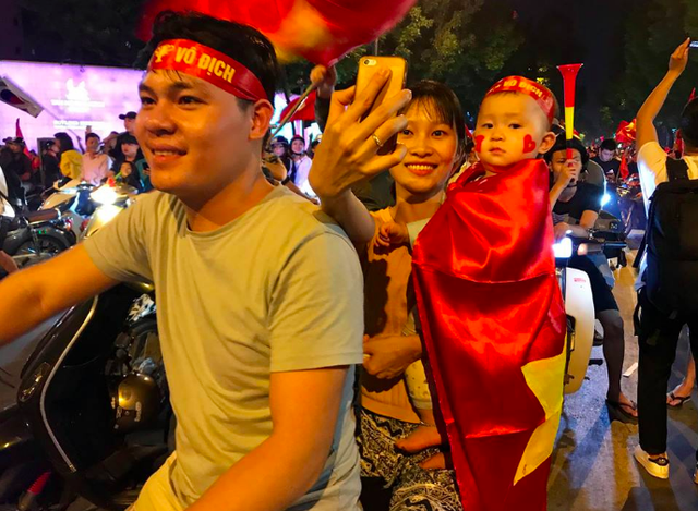Người dân cả nước sôi động mừng chiến thắng của đội tuyển Việt Nam - 8
Em bé được bố mẹ choàng lên người lá cờ đỏ sao vàng để ăn mừng chiến thắng