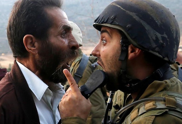 Thế giới năm 2018 qua những khoảnh khắc ấn tượng (1) - 2
Một người đàn ông Palestine tranh cãi với binh sĩ Israel trong cuộc đụng độ liên quan tới việc Israel ra lệnh đóng cửa một trường học của Palestine gần Nablus, Bờ Tây hôm 15/10.