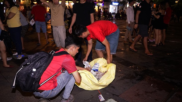 Đáng yêu hình ảnh bạn trẻ dọn rác trên phố sau trận Việt Nam - Philippines - 3 Các bạn tận dụng phế phẩm do những cỏ động viên để lại để dọn rác