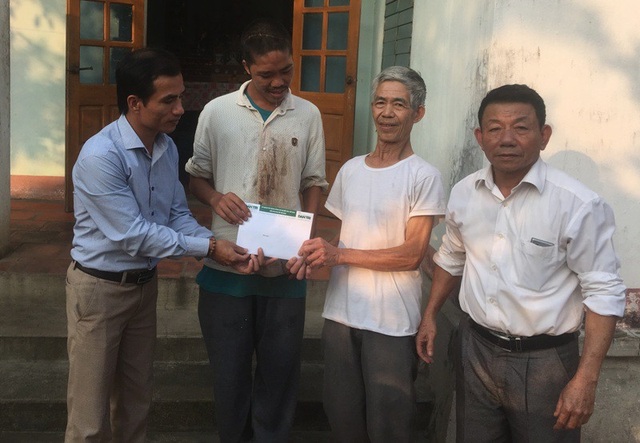Quà nhân ái tiếp tục đến với gia đình ông Đỗ Văn Cường - 2 Phóng viên Dân trí và đại diện chính quyền địa phương trao quà bạn đọc ủng hộ tới gia đình ông Cường.