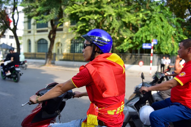 CĐV cắt tóc hình HLV Park Hang Seo, đốt pháo sáng diễu hành trước trận đấu - 11 Các thành viên được phổ biến đội mũ bảo hiểm, không vượt đèn đỏ. Một thành viên trong đoàn khoác lá cờ Tổ quốc trên vai.