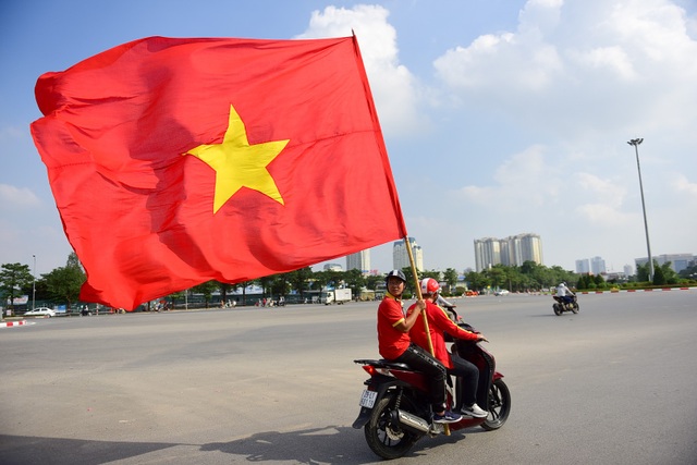 CĐV cắt tóc hình HLV Park Hang Seo, đốt pháo sáng diễu hành trước trận đấu - 2 Một cổ động viên lâu năm là người cầm cờ và giữ nhịp cổ động trên đường phố.