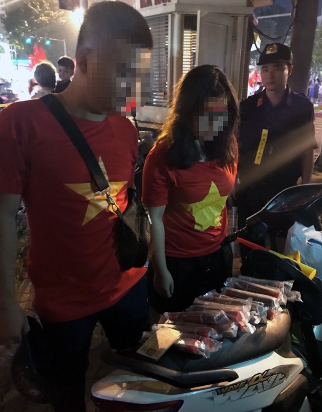 Hà Nội: Đôi nam nữ mang pháo sáng đi cổ vũ bóng đá - 1 Đôi nam nữ mang pháo sáng đi cổ vũ bóng đá bị cảnh sát chặn dừng.