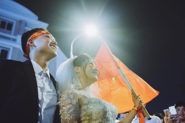 Cặp đôi “hoãn” chụp ảnh cưới, đi “bão” mừng chiến thắng của đội tuyển Việt Nam - 3 Dù vô tình nhưng cô dâu, chú rể cho biết may mắn lại được hòa vào biển người ăn mừng chiến thắng. Ảnh: Hoàng Ken