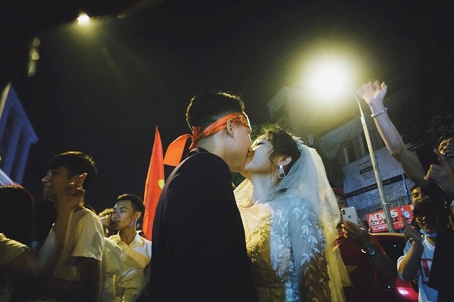Cặp đôi “hoãn” chụp ảnh cưới, đi “bão” mừng chiến thắng của đội tuyển Việt Nam - 1 Trong rừng cờ đỏ, sao vàng cô dâu chú rể ngập tràn hạnh phúc. Ảnh: Hoàng Ken