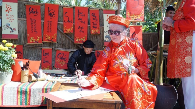 Du khách quốc tế hào hứng trải nghiệm Tết Việt - 13 Sau khi gói bánh chưng, vị khách này tự tay viết thư pháp ở phố ông Đồ