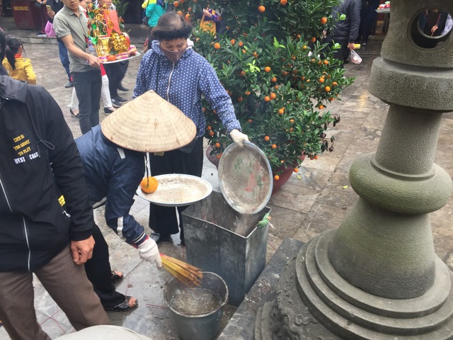 Hàng vạn người chen chân “vay tiền” ở Đền Bà Chúa Kho - 5 Hai cụ bà luôn tục rút hương du khách thắp dúng vào xô nước cho đỡ khói