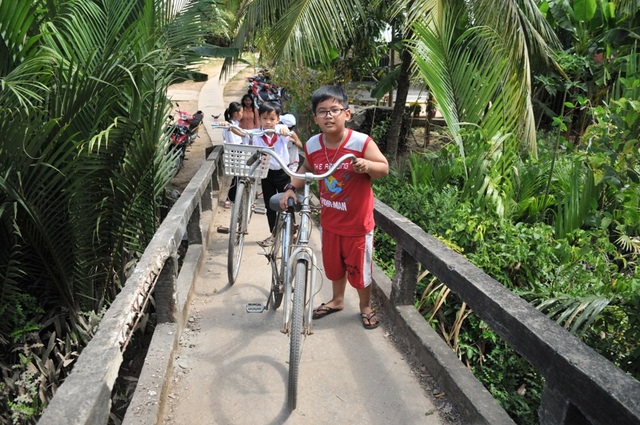 Mong chờ một cây cầu mới ở Rạch Đùi - 3 Mặt cầu nhỏ, dốc cao nên các em học sinh đi xe đạp phải dẫn bộ qua cầu...