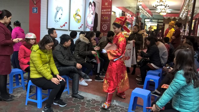 Ngày Vía Thần Tài: Cửa hàng đông đặc, nhà vàng trúng đậm - 4
Đến gần trưa, mưa ngày càng nặng hạt, người dân vẫn xếp hàng chờ đến lượt. Người người xếp ghế ngồi đợi đến lượt mua vàng tại Bảo Tín Minh Châu