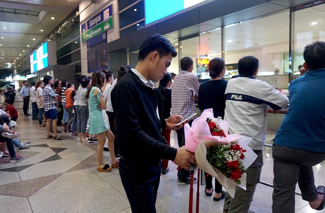 Vỡ òa cảm xúc ở "cửa ngõ" quê nhà trong những ngày giáp Tết - 4 Có chàng trai ôm bó hoa tươi chờ đợi bạn.