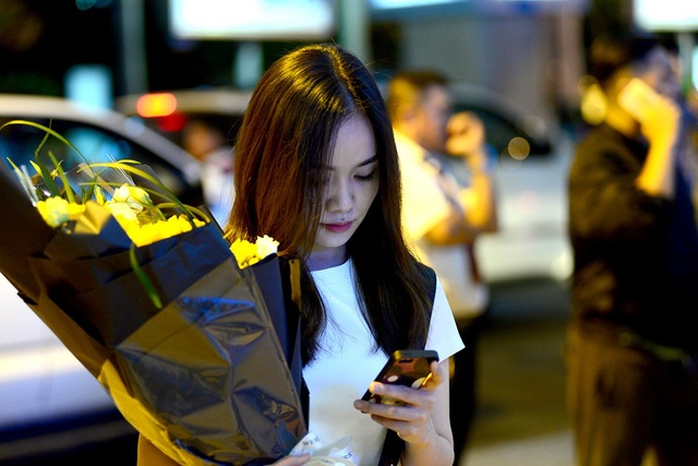 Vỡ òa cảm xúc ở "cửa ngõ" quê nhà trong những ngày giáp Tết - 11 Cô gái ôm bó hoa tươi đứng chờ đợi.