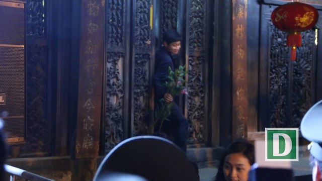 
Sau khi vào dâng hương, nhiều người bước ra khỏi đền với một cành hoa trên tay
