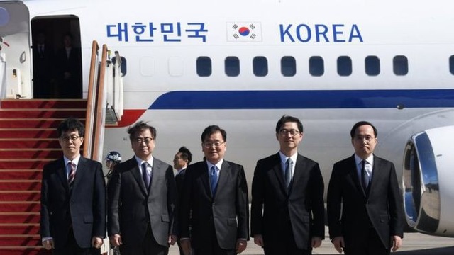 Ông Kim Jong-un lần đầu đón quan chức Hàn Quốc - 1 Ông Chung Eui-yong (giữa) và ông Suh Hoon (thứ hai từ trái sang) chụp ảnh cùng các quan chức trong phái đoàn Hàn Quốc tới Triều Tiên. (Ảnh: BBC)