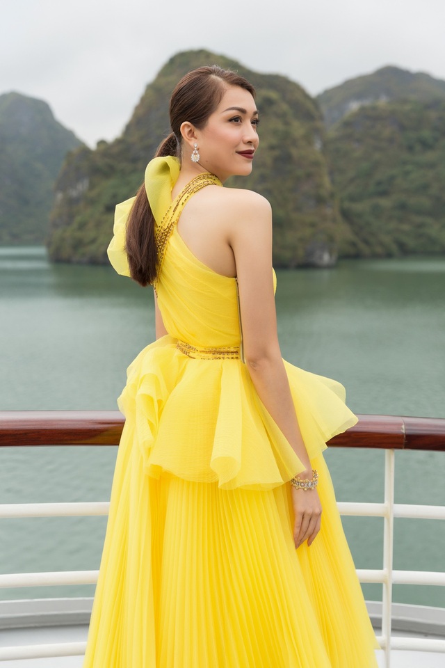 Á hậu Lệ Hằng tình tứ cùng MC Phan Anh giữa Vịnh Hạ Long - 2 Người đẹp sinh năm 1993 diện bộ váy lệch vai tông vàng.