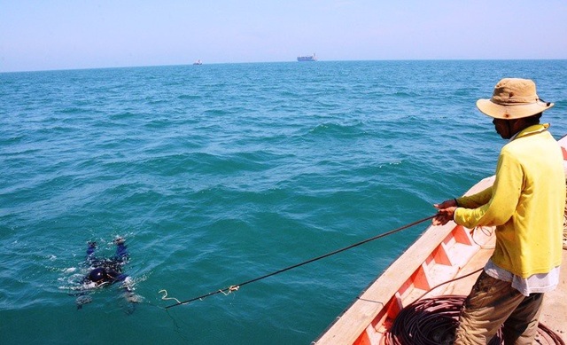 Nghề lặn xuống ngoi lên vớt tiền triệu bỏ túi - 2 Thợ lặn đang được người hậu cần lôi lên từ đáy biển.
