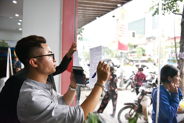 Hà Nội: Người dân mệt mỏi đi bổ sung thông tin cá nhân cho thuê bao - 8 Một khách hàng phải đứng viết vào phiếu điền thông tin.