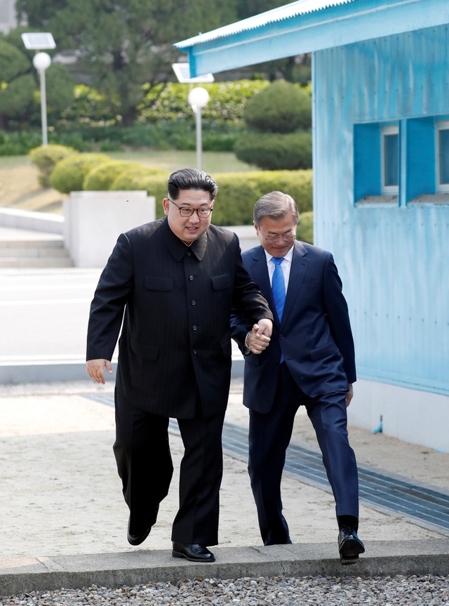 Ông Kim Jong-un hứa không quấy rầy giấc ngủ của Tổng thống Moon bằng tên lửa - 2 Khoảnh khắc hai nhà lãnh đạo nắm tay bước qua ranh giới quân sự (Ảnh: Reuters)