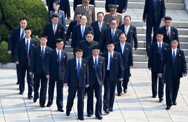 Khi nhà lãnh đạo Kim Jong-un bắt đầu di chuyển gần đến khu vực biên giới giữa Triều Tiên và Hàn Quốc tại làng đình chiến Panmunjom hôm 27/4 để gặp Tổng thống Moon Jae-in, một nhóm vệ sĩ đã nhanh chóng tạo hình chữ V, tạo thành một lớp rào chắn bảo vệ nhà lãnh đạo. (Ảnh: Reuters)