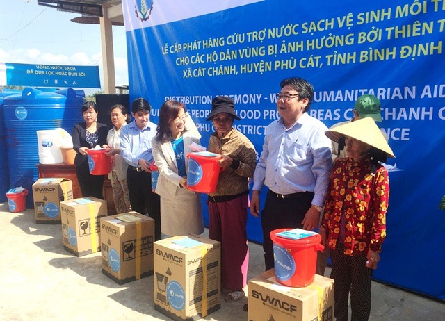 Dân vùng lũ hết nỗi lo “khát” nước sạch trong mùa lũ - 3 Người dân xã Cát Chánh phấn khởi khi nhận hàng cứu trợ.