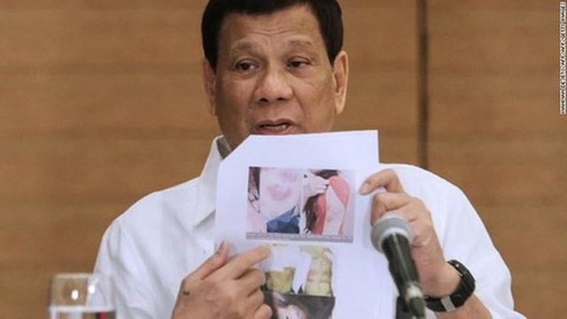 Philippines cấm dài hạn xuất khẩu lao động sang Kuwait - 1
Tổng thống Philippines Rodrigo Duterte cầm ảnh một lao động nước này bị bạo hành ở Kuwait. (Ảnh: Getty Images)