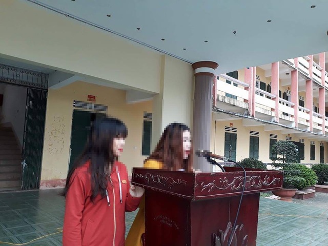 Vụ nữ sinh lớp 11 bị lột áo: Người đánh xin lỗi nữ sinh trước toàn trường - 1 Hai đối tượng Dung và Huyền đứng trước trường xin lỗi em L. cùng toàn thể nhà trường.