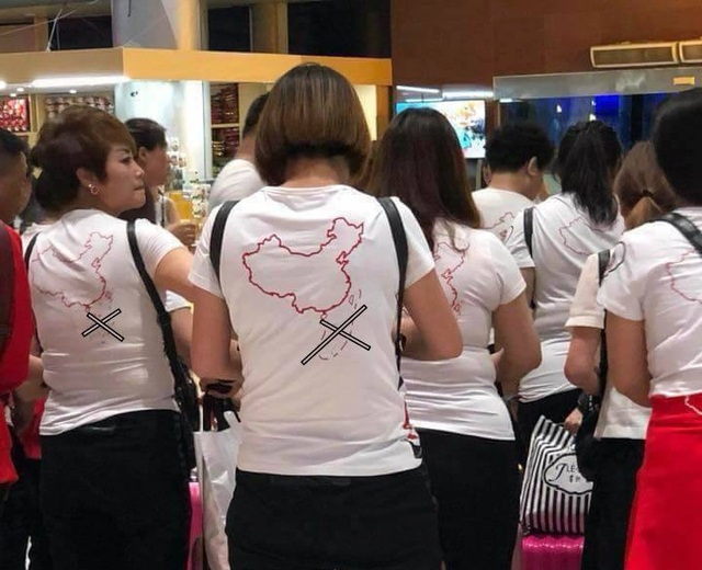 
Nhóm du khách Trung Quốc mặc áo hình đường lưỡi bò phi pháp khi nhập cảnh tại sân bay Cam Ranh khuya 13-5 - Ảnh: Facebook
