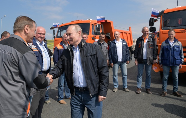 Tổng thống Putin lái xe tải thông cầu nối đất liền Nga với Crimea - 2 Sau khi nói lời cảm ơn và bắt tay những người đứng đầu các nhóm tham gia xây dựng cây cầu, Tổng thống Putin đã ngồi vào ghế lái của một xe tải màu cam để di chuyển qua cây cầu.