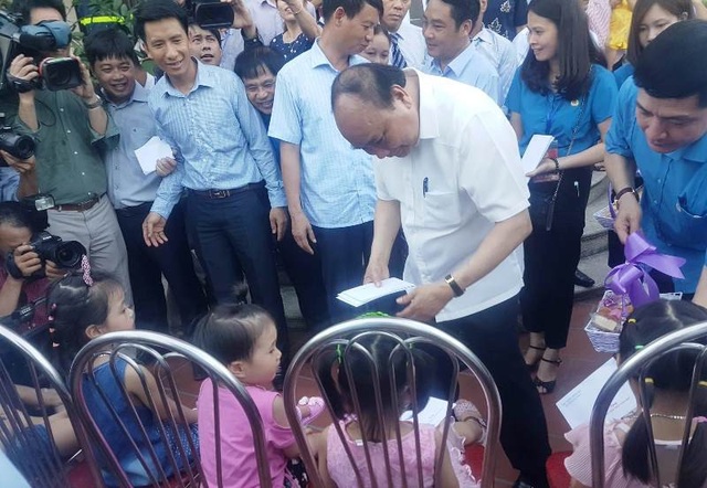 Thủ tướng kiểm tra thiết chế Công đoàn và thăm hỏi công nhân tại Hà Nam - 4 Thủ tướng Nguyễn Xuân Phúc tặng quà cho con em người lao động đang làm việc tại các doanh nghiệp đóng trên địa bàn KCN Đồng Văn