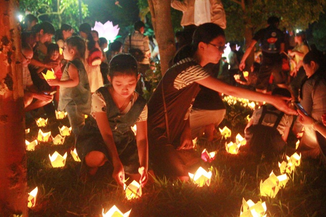 Sông Hương rực sáng trong đêm hội 30.000 hoa đăng - 8 Người dân thắp đèn hoa đăng, mỗi ngọn đèn hoa đăng được đốt lên là một tâm niệm thiện lành được thắp sáng