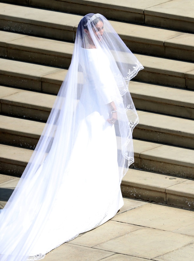 Cô dâu Hoàng gia Meghan rạng ngời trong hai bộ váy cưới “thường dân” - 2
Đó là một chiếc váy thiết kế đơn giản song khá tinh tế với đuôi váy dài và chiếc voan dài 5m với họa tiết hoa đặc trưng của 53 quốc gia trong Khối thịnh vượng chung Anh.