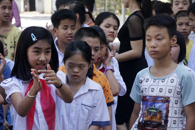 Lễ bế giảng đặc biệt của học sinh khiếm thính ở Hà Nội - 2
Khóa học 2017-2018, trường Hy Vọng chỉ có 79 học sinh, trong đó 56 em khiếm thính, số còn lại chậm phát triển trí tuệ. Trong ảnh, một em học sinh nữ dùng ngôn ngữ cử chỉ để nói chuyện với các bạn.