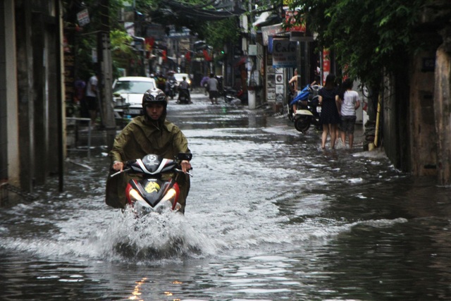 Phố phường Hà Nội bì bõm sau cơn mưa chiều cuối tuần - 1 Phố Nguyễn Chính (Hoàng Mai) ngập sâu, nước dâng cao ngập gần hết bánh xe máy.