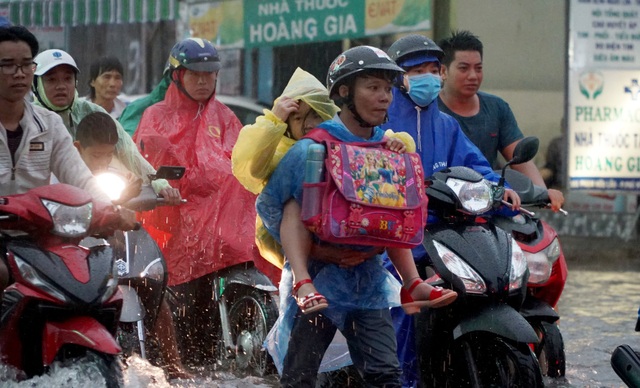 Sài Gòn mưa to, học sinh bì bõm lội nước về nhà - 11
Do xe chết máy, anh Tài đành gửi xe rồi cõng bộ đưa con về nhà cho kịp bữa tối