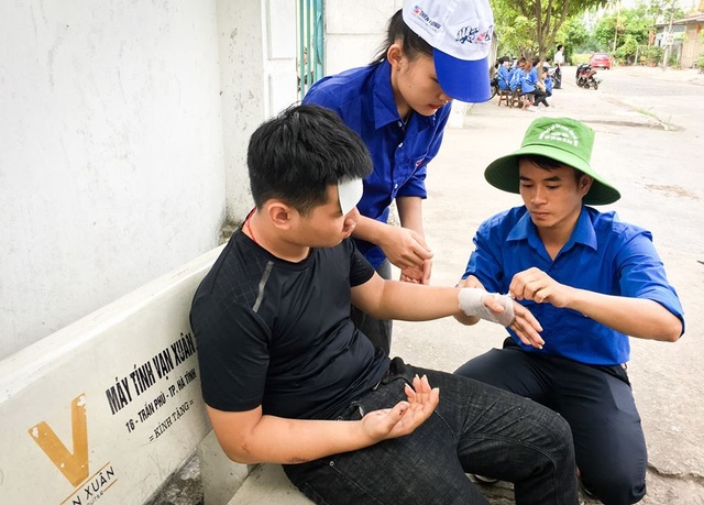 Một thí sinh ở điểm thi trường THCS Lê Văn Thiêm (TP Hà Tĩnh) bị tai nạn giao thông được các bạn tình nguyện viên băng bó vết thương