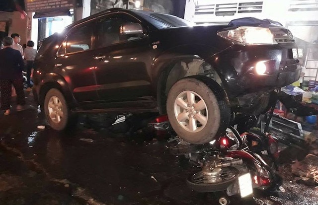 Xe Fortuner cuốn 4 xe máy vào gầm, 1 người nguy kịch - 1 Chiếc ô tô cuốn nhiều xe máy vào gầm.