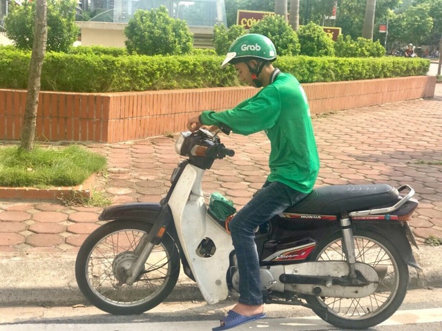 Không nghỉ hè, sinh viên ở lại Hà Nội làm “xe ôm công nghệ” - 2 Sinh viên chạy xe ôm đứng chờ khách ngoài trời nắng nóng (Ảnh: Phương Ngân)