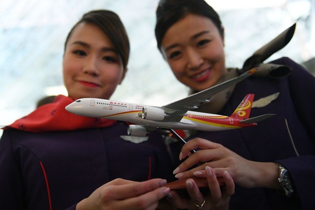 Vẻ đẹp của các tiếp viên hàng không khắp thế giới - 15 Hai nữ tiếp viên hãng Hong Kong Airlines cầm trên tay mô hình máy bay thu nhỏ. (Ảnh: Sputnik)